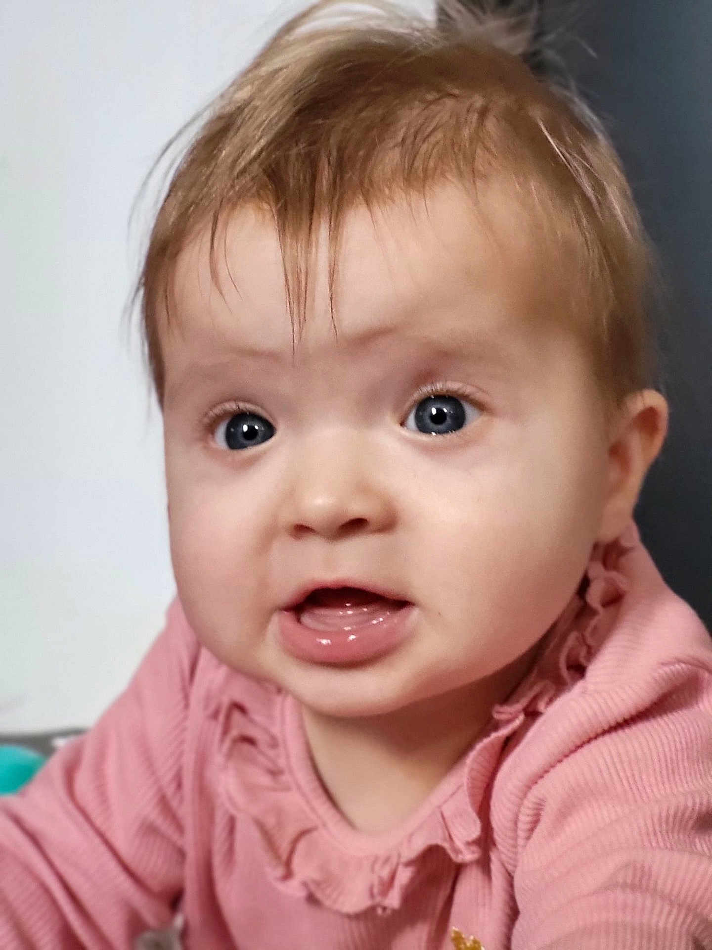Luna participe au concours pour gagner de l'argent avec cette photo : baby, infant, portrait, close_up, face, blue_eyes, pink_clothing, ruffles, mouth_open, cheeks, eyelashes, light_brown_hair, skin, cute, surprised_expression, indoor, soft_lighting, child, baby_girl, toddler