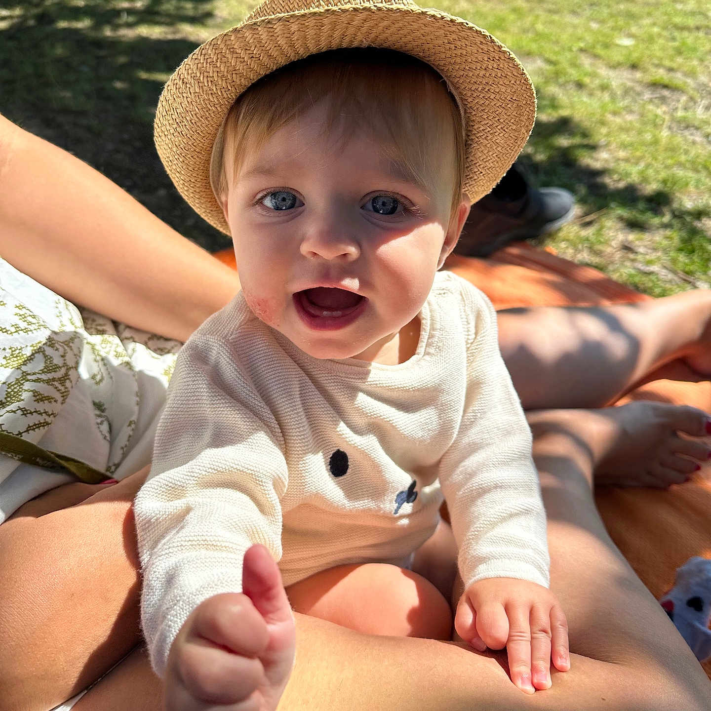 Violette a rejoint le concours — aidez-le/la à gagner de superbes lots ! baby, blue_eyes, casual, child, clothing, face, grass, hand, happy, hat, lap, outdoor, person, relaxation, skin, smile, straw_hat, summer, sunlight, thumbs_up