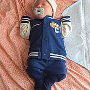 Luka is registered to the contest to win money with this photo: baby, bed, blanket, clothing, cozy, cute, hat, indoors, infant, jacket, laying, navy_blue, newborn, pacifier, pants, pattern, peaceful, person, sleeping, soft_lighting