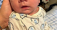 Luka is registered to the contest to win money with this photo: baby, newborn, child, infant, portrait, face, eyes, wide_eyed, mouth, hand, pajamas, bear_pattern, clothing, blanket, bed, indoors, cozy, close_up, family, photography