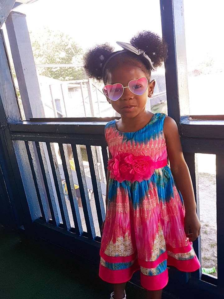 Jaleah is registered to the contest to win money with this photo: child, clothing, cool, dress, eyewear, glasses, magenta, pattern, person, pink, smile, summer, sunglasses, textile, toddler, vacation