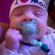 Maloyann a rejoint le concours — aidez-le/la à gagner de superbes lots ! accessory, baby, beads, child, closeup, clothing, cute, face, hand, hat, headwear, indoor, infant, newborn, pacifier, peaceful, person, resting, skin, sleeping