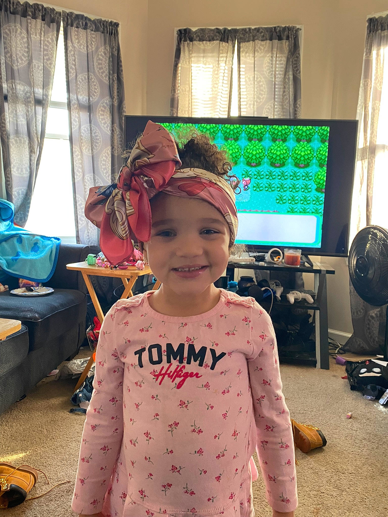 Luna is registered to the contest to win money with this photo: baby_toddler_clothing, bag, blue, child, costume, curtain, fashion_design, fun, happy, headwear, home_appliance, joy, luggage_and_bags, mechanical_fan, pattern, person, room, sleeve, smile, television