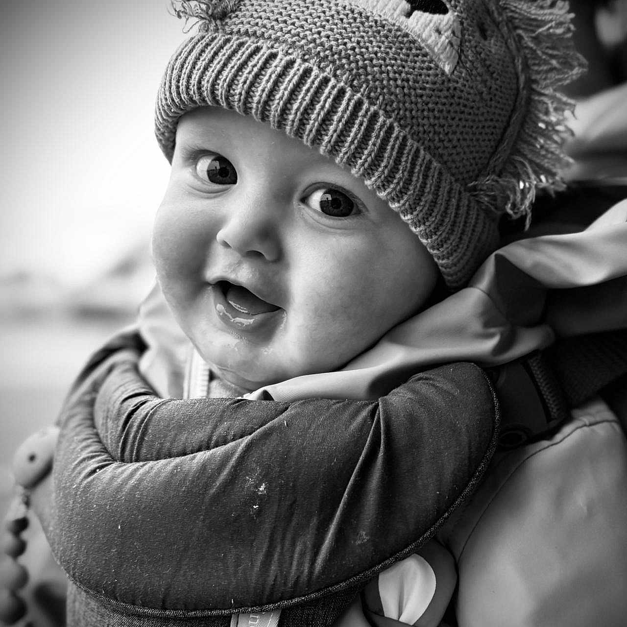 Albert is registered to the contest to win money with this photo: baby, beanie, bodypart, bonnet, cap, clothing, coat, face, finger, glove, hand, happy, hat, head, knitwear, person, photography, portrait, smile, sweater