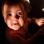 Riley is registered to the contest to win money with this photo: baby, child, face, eyes, shadow, light, skin, expression, portrait, indoor, cute, infant, hand, cheeks, mouth, curious, young, person, closeup, natural_light