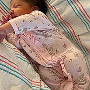 Emely is registered to the contest to win money with this photo: baby, newborn, infant, sleeping, onesie, pink_clothing, ruffles, hospital_blanket, striped_blanket, bedding, crib, side_profile, closed_eyes, tiny_hand, dark_hair, cozy, peaceful, portrait, soft_lighting, newborn_room