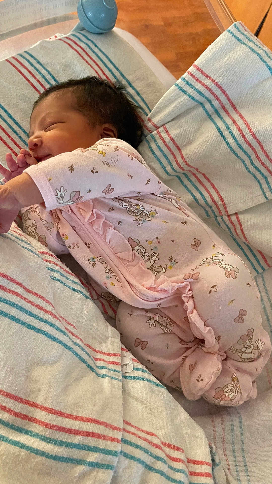 Emely is registered to the contest to win money with this photo: baby, newborn, infant, sleeping, onesie, pink_clothing, ruffles, hospital_blanket, striped_blanket, bedding, crib, side_profile, closed_eyes, tiny_hand, dark_hair, cozy, peaceful, portrait, soft_lighting, newborn_room