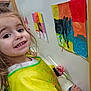 art, artwork, brush, child, colorful, creative, drawing, expression, girl, hands, happy, indoor, paint, painting, person, portrait, smile, wall, yellow_smock, young_artist
