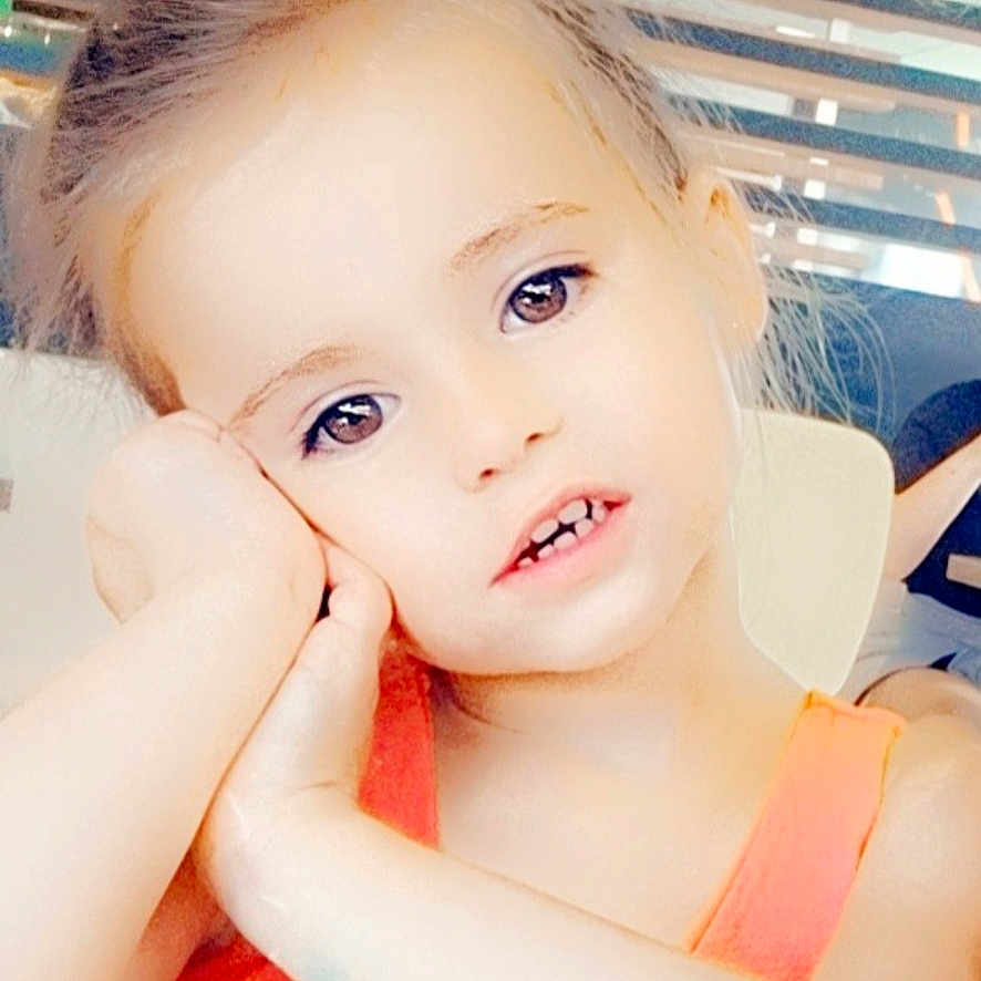 Mia participe au concours pour gagner de l'argent avec cette photo : bright, casual, child, cute, expression, eyes, face, girl, hair, hand, indoor, modern_interior, orange_clothing, person, portrait, resting_head, sitting, skin, table, young