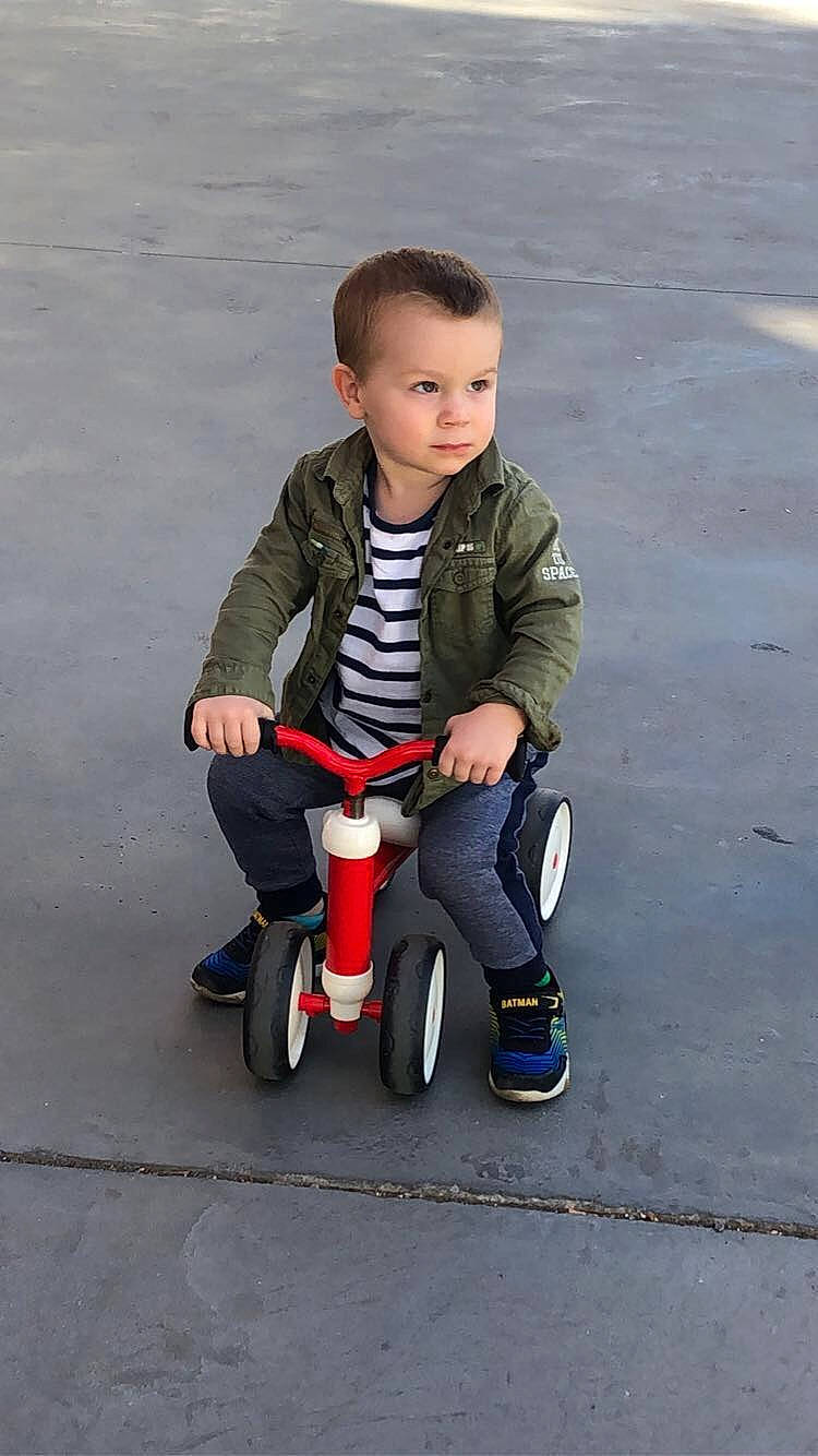 Timeo participe au concours pour gagner de l'argent avec cette photo : asphalt, baby_toddler_clothing, bicycle, boot, carmine, child, electric_blue, face, fun, happy, leg, person, recreation, rolling, shoe, sitting, smile, sneakers, tire, toddler