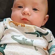 Klayse joined the competition — help win amazing prizes! baby, infant, face, dinosaur_pattern, onesie, clothing, child, portrait, cute, young, skin, eyes, head, expression, lying_down, soft_lighting, indoor, closeup, person, adorable