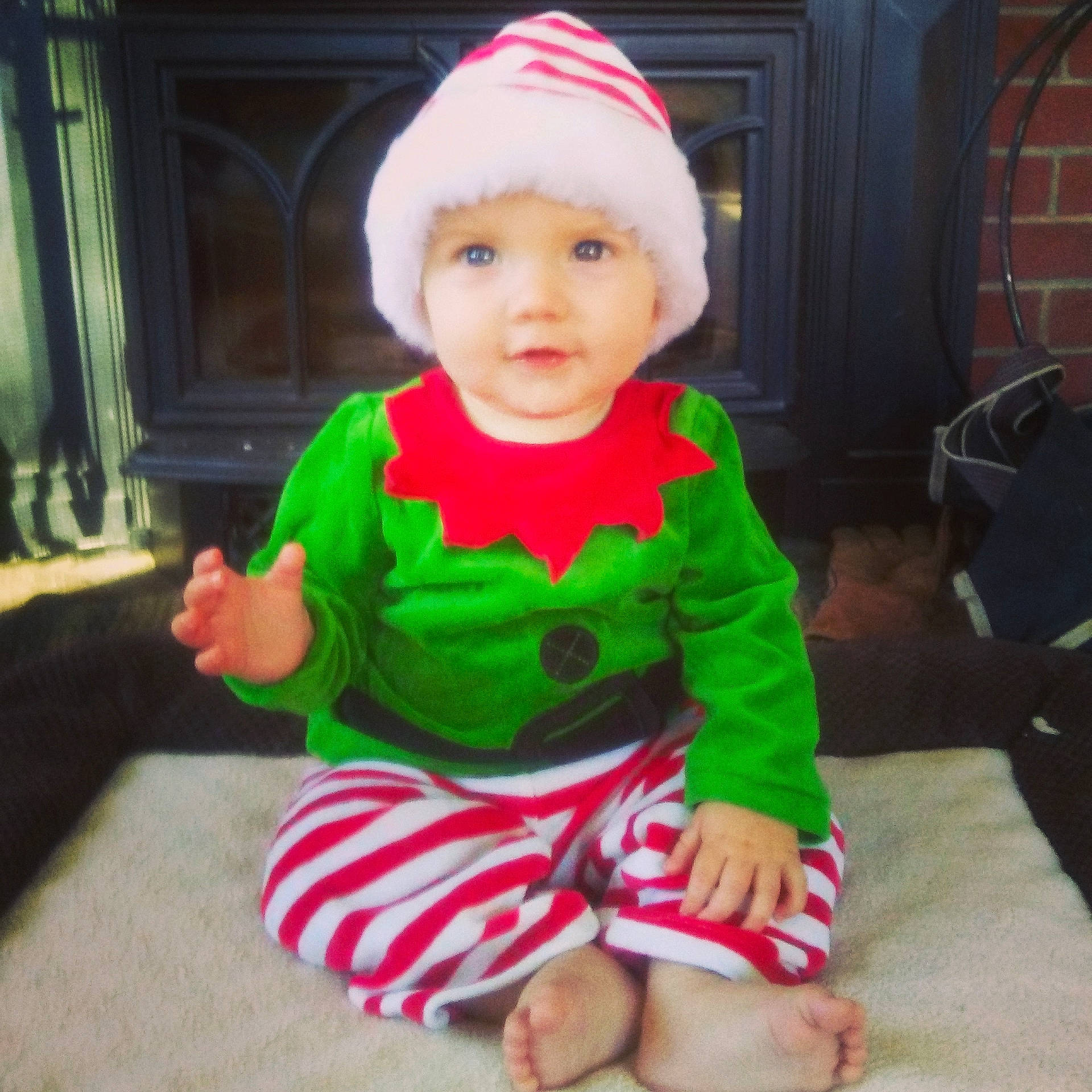 Timothy is registered to the contest to win money with this photo: baby, baby_toddler_clothing, child, christmas, christmas_eve, costume, face, fictional_character, head, headwear, holiday, person, pink, plant, play, sitting, sleeve, smile, toddler