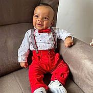 Lélio a rejoint le concours — aidez-le/la à gagner de superbes lots ! baby, child, smiling, red_pants, bow_tie, suspenders, white_shirt, shoes, sitting, chair, indoor, cute, happy, portrait, infant, fashion, clothing, person, face, furniture