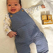 Nathan joined the competition — help win amazing prizes! baby, smiling, infant, blue_romper, animal_print, wooden_blocks, milestone, 3_months, white_blanket, cute, happy, portrait, child, lying_down, soft_texture, cozy_clothing, face, hand, cute_expression, indoors