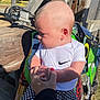 baby, child, person, hand, holding_hands, outdoor, sunlight, dirt_bike, motorcycle, wood, clothing, white_shirt, checkered_pants, nike_logo, grip, closeup, portrait, nature, daylight, cute