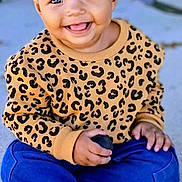 Jaz'Lyn joined the competition — help win amazing prizes! toddler, child, smiling, leopard_print, sweater, blue_pants, sitting, carpet, indoor, happy, topknot, cute, playful, hands, feet, sock, portrait, person, young_child, holding_object