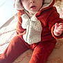 baby, carpet, child, colorful, curious, cute, expression, face, floor, furniture, headwear, indoor, onesie, open_mouth, person, plush, reindeer_costume, seated, toy, warm_clothing