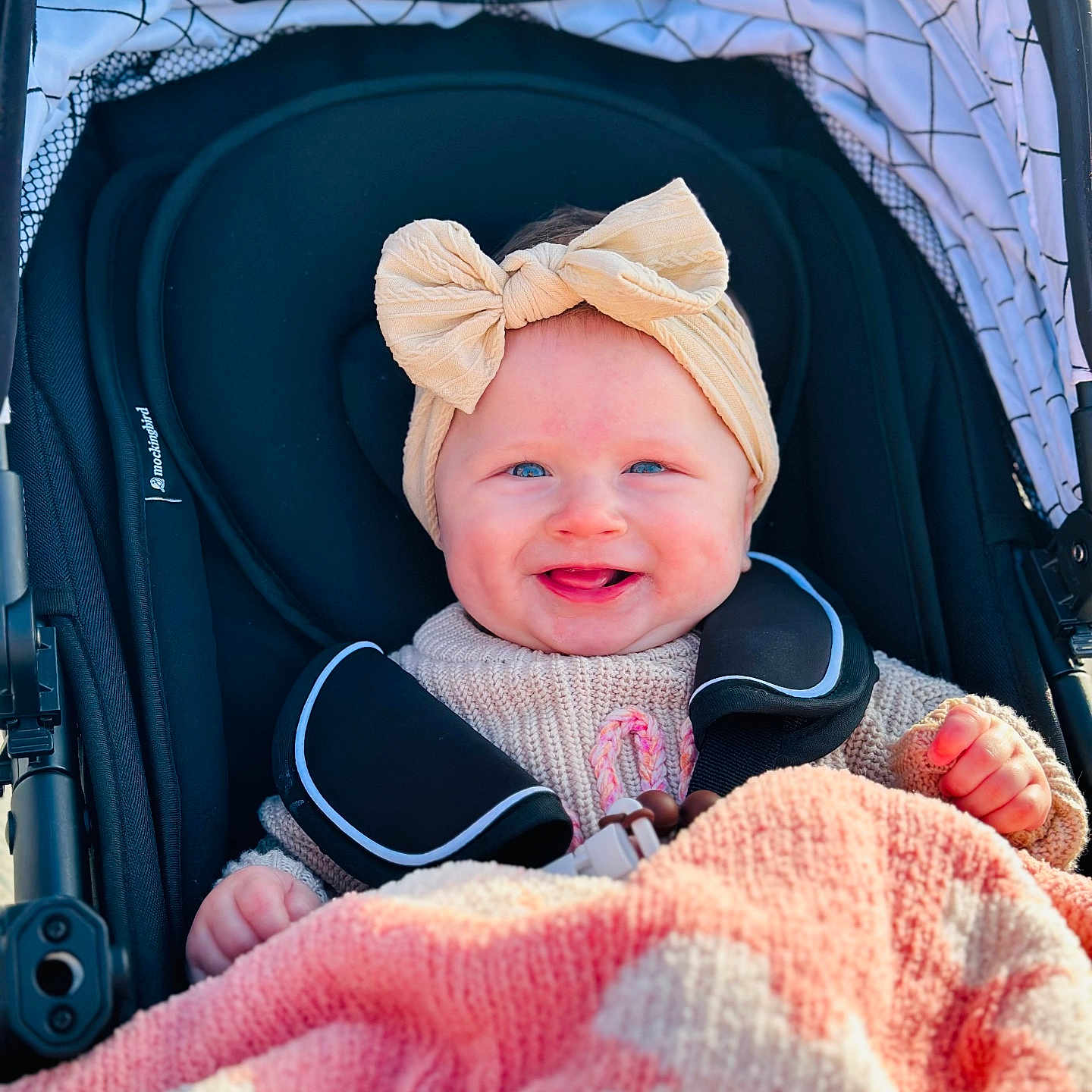 Dallas joined the competition — help win amazing prizes! baby, babylaughing, blanket, cap, clothing, coat, face, happy, hat, head, jacket, laughing, newborn, person, photography, portrait, smile, stroller, transportation, vehicle