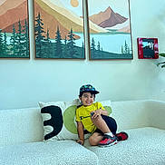 Zohan joined the competition — help win amazing prizes! child, boy, smiling, yellow_shirt, cap, red_shoes, couch, white_couch, pillows, wall_art, painting, mountains, indoor, living_room, plant, decor, happy, casual_clothing, portrait, furniture