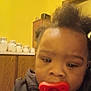 Kayden is registered to the contest to win money with this photo: baby, pacifier, indoor, child, face, hair, cabinet, wall, yellow, clothing, furniture, room, head, portrait, infant, young_child, person, closeup, blur, expression