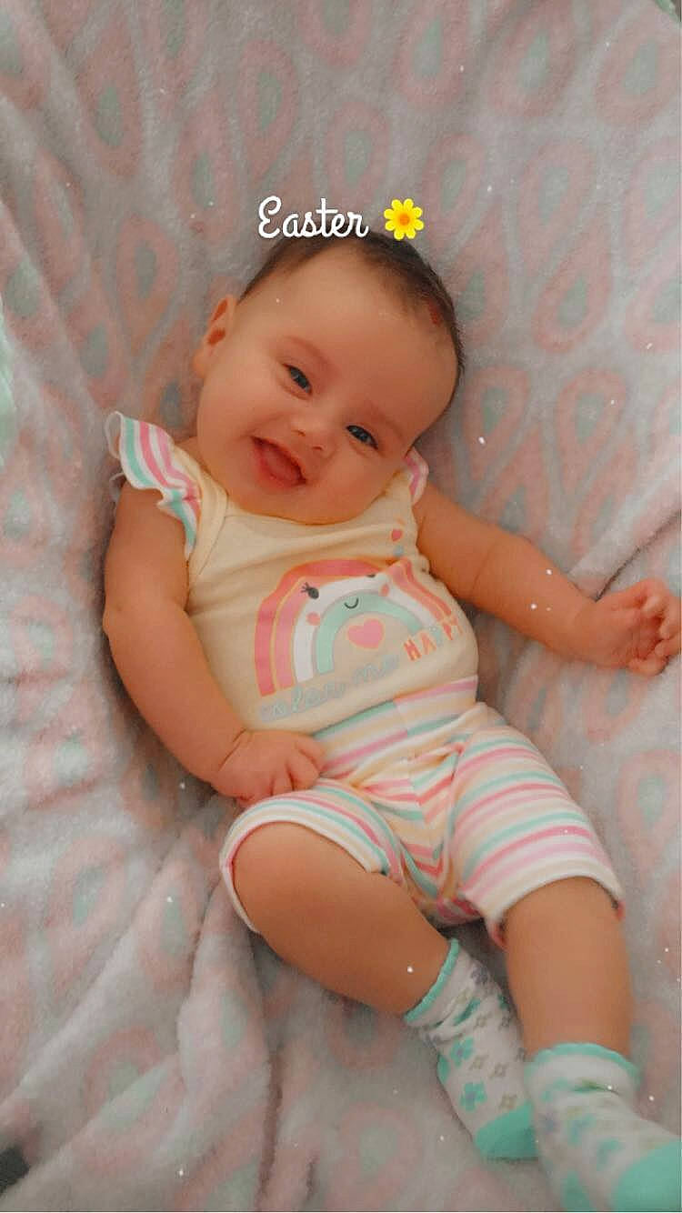 Esmeray is registered to the contest to win money with this photo: arm, baby, baby_toddler_clothing, cheek, child, comfort, eye, finger, fun, happy, human_leg, iris, knee, pattern, person, pink, skin, smile, stomach, thigh