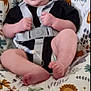 Noah is registered to the contest to win money with this photo: baby, infant, smiling, baby_seat, harness, patterned_fabric, animal_print, leaf_print, black_clothing, barefoot, flooring, wood_floor, cute, child, indoors, seat, sitting, happy, small_hands, legs
