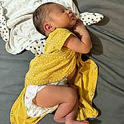 Sarah a rejoint le concours — aidez-le/la à gagner de superbes lots ! baby, newborn, sleeping, diaper, yellow_clothing, polka_dots, infant, cute, peaceful, resting, child, soft_fabric, lying_down, skin, head, foot, hand, indoors, person, toddler