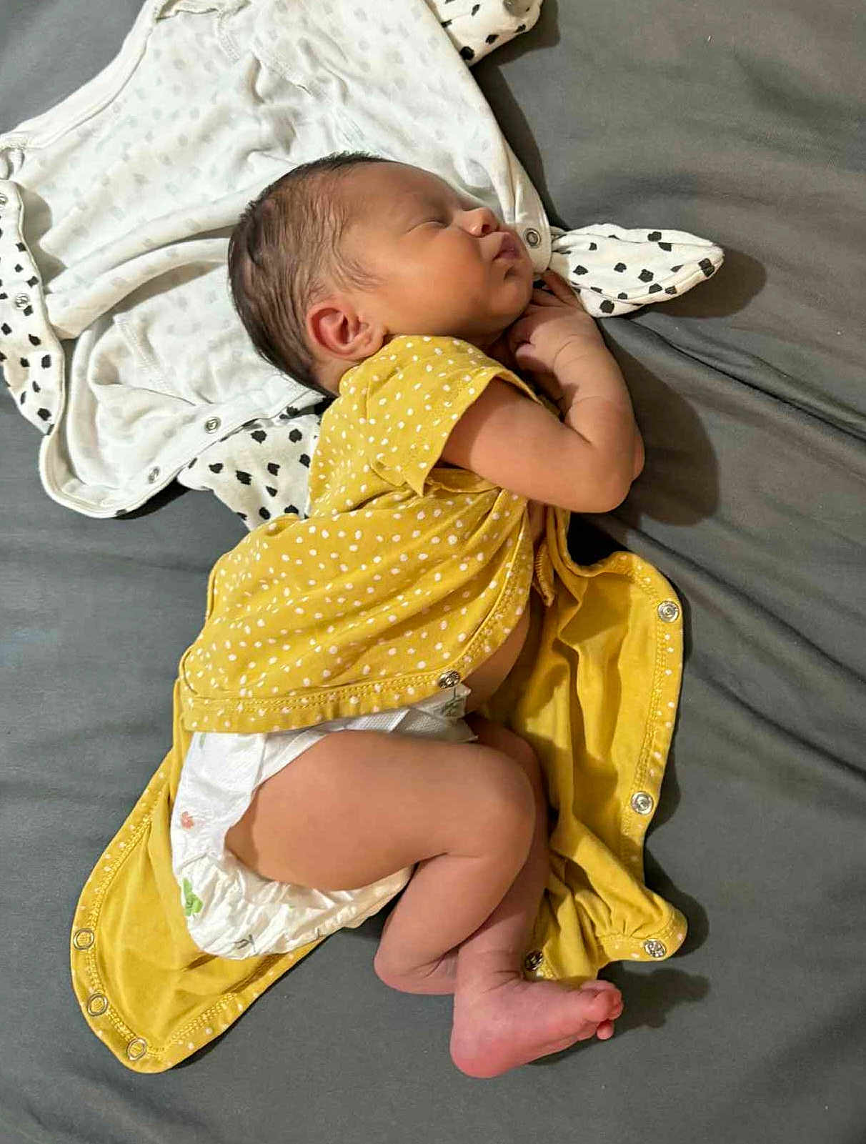 Sarah a rejoint le concours — aidez-le/la à gagner de superbes lots ! baby, newborn, sleeping, diaper, yellow_clothing, polka_dots, infant, cute, peaceful, resting, child, soft_fabric, lying_down, skin, head, foot, hand, indoors, person, toddler