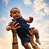 baby, child, denim_overalls, white_shirt, socks, hands, adult, sky, clouds, sunset, outdoor, portrait, smile, happy, playful, person, holding, nature, fun, family