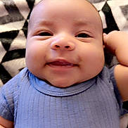 Zayden is registered to the contest to win money with this photo: baby, smiling, blue_onesie, blanket, patterned_blanket, cheeks, face, infant, cute, lying_down, happy, child, skin, head, arm, hand, portrait, toddler, indoors, soft_texture
