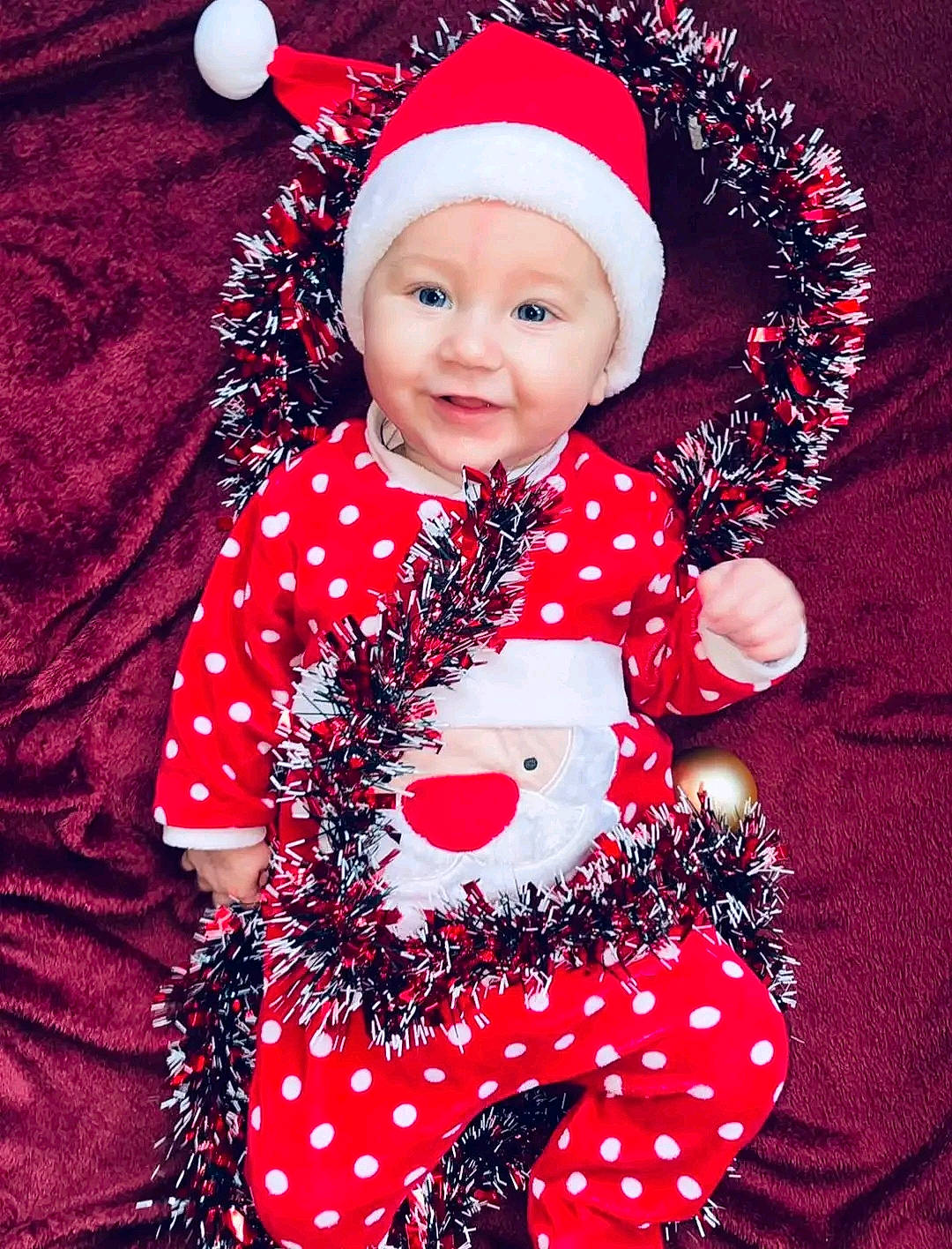 Thymeo participe au concours pour gagner de l'argent avec cette photo : baby, baby_toddler_clothing, cap, christmas, christmas_eve, costume_hat, entertainment, event, face, happy, headwear, holiday, human_body, magenta, pattern, person, pink, red, santa_claus, sleeve