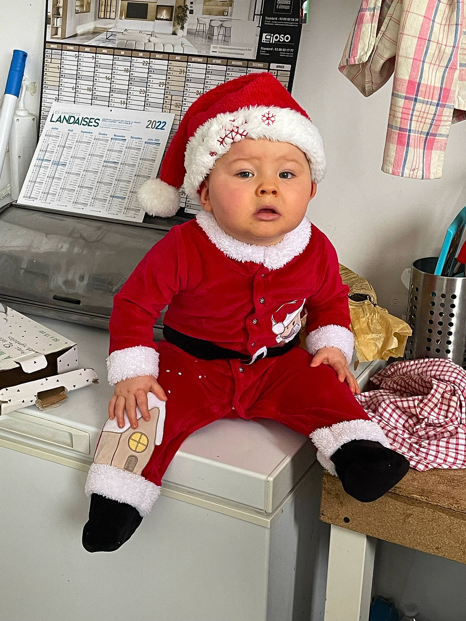 Maylone a rejoint le concours — aidez-le/la à gagner de superbes lots ! baby, baby_toddler_clothing, beanie, cap, carmine, child, christmas, christmas_eve, costume_hat, fictional_character, happy, headwear, holiday, lap, magenta, person, room, santa_claus, sitting, sleeve
