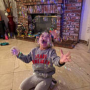 Jasmine joined the competition — help win amazing prizes! child, bubbles, indoor, brick_fireplace, toy, floor, tiled_floor, sweatshirt, pants, playful, happy, person, home, decor, reaching, smiling, kneeling, casual_clothing, living_room, fun