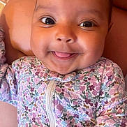 Eliana is registered to the contest to win money with this photo: baby, infant, smile, tongue, face, eyes, floral, clothing, onesie, cute, child, portrait, closeup, happy, skin, human, person, hand, babywear, indoors