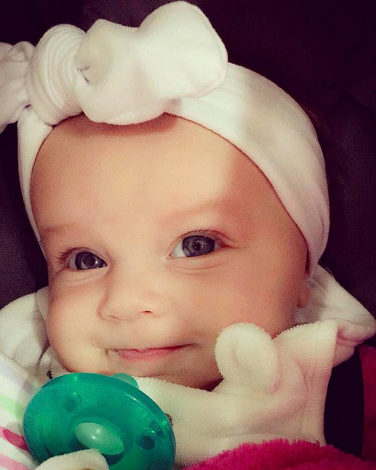 Kenlee is registered to the contest to win money with this photo: cheek, child, chin, close_up, ear, eye, face, forehead, hair_accessory, head, infant, iris, joy, lip, mouth, nose, person, pink, product, skin