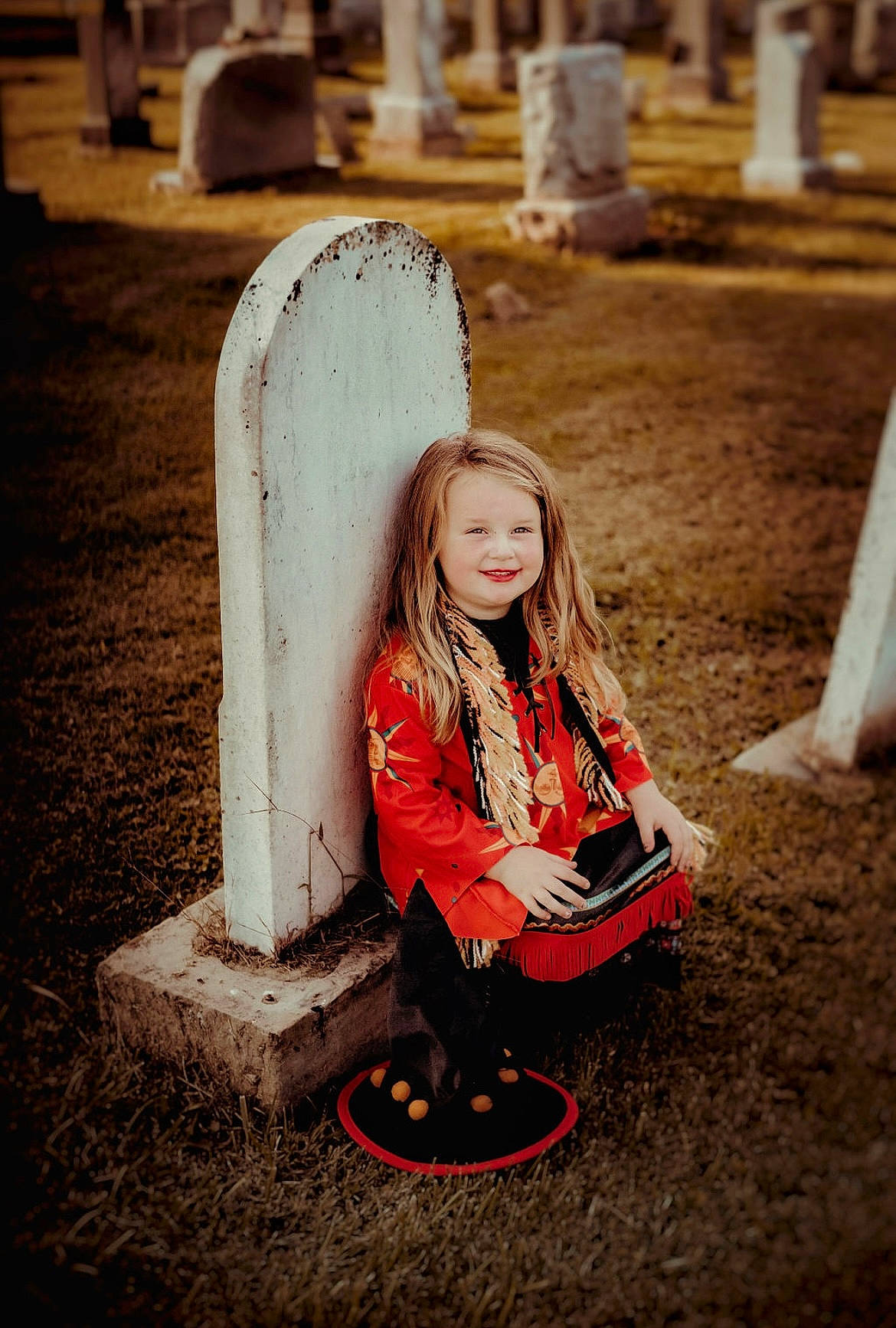 Kenlee is registered to the contest to win money with this photo: blond, boot, cemetery, child, eye, flash_photography, fun, grass, grave, happy, joy, light, people_in_nature, person, photograph, sitting, smile, snapshot, tints_and_shades, toddler