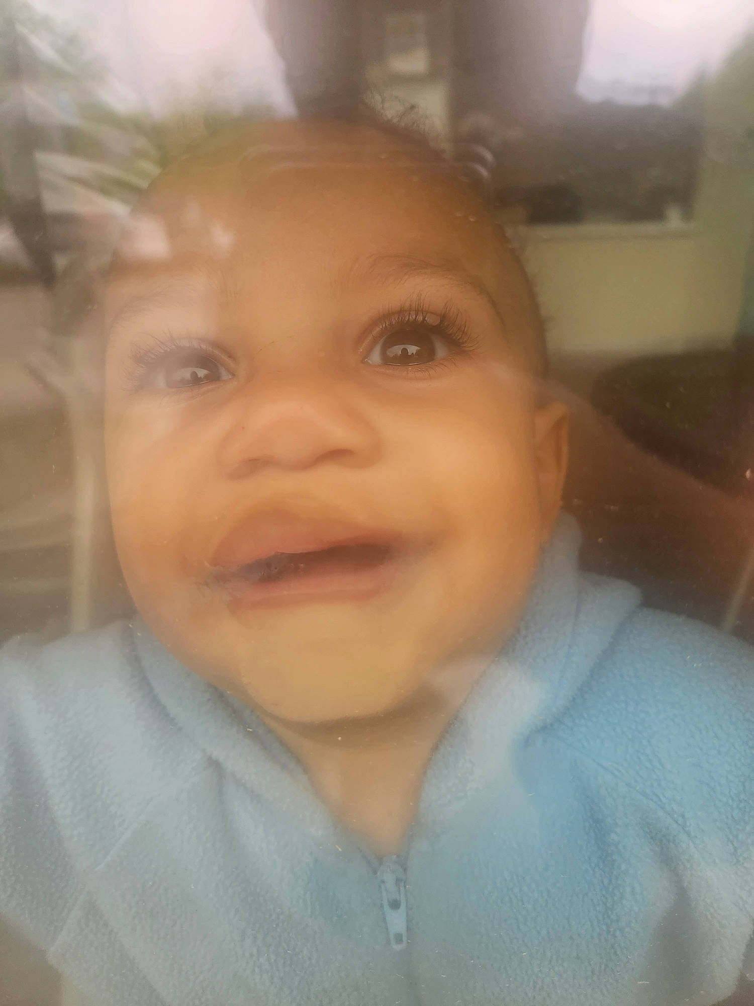 Octavius is registered to the contest to win money with this photo: baby, baby_toddler_clothing, cheek, child, ear, eyelash, forehead, fun, happy, jaw, joy, lip, nose, person, sleeve, smile, toddler, tree, window