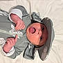Grayson is registered to the contest to win money with this photo: baby, infant, child, hat, clothing, grey, white, turtle, pattern, mouth_open, hands, lying_down, bed, cute, playful, face, skin, young, apparel, indoor