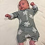 baby, infant, lying_down, grey_outfit, turtle_pattern, bed, white_sheet, arms_stretched, legs_bent, looking_away, cute, indoors, child, newborn, soft_lighting, skin, head, feet, sleepwear, resting