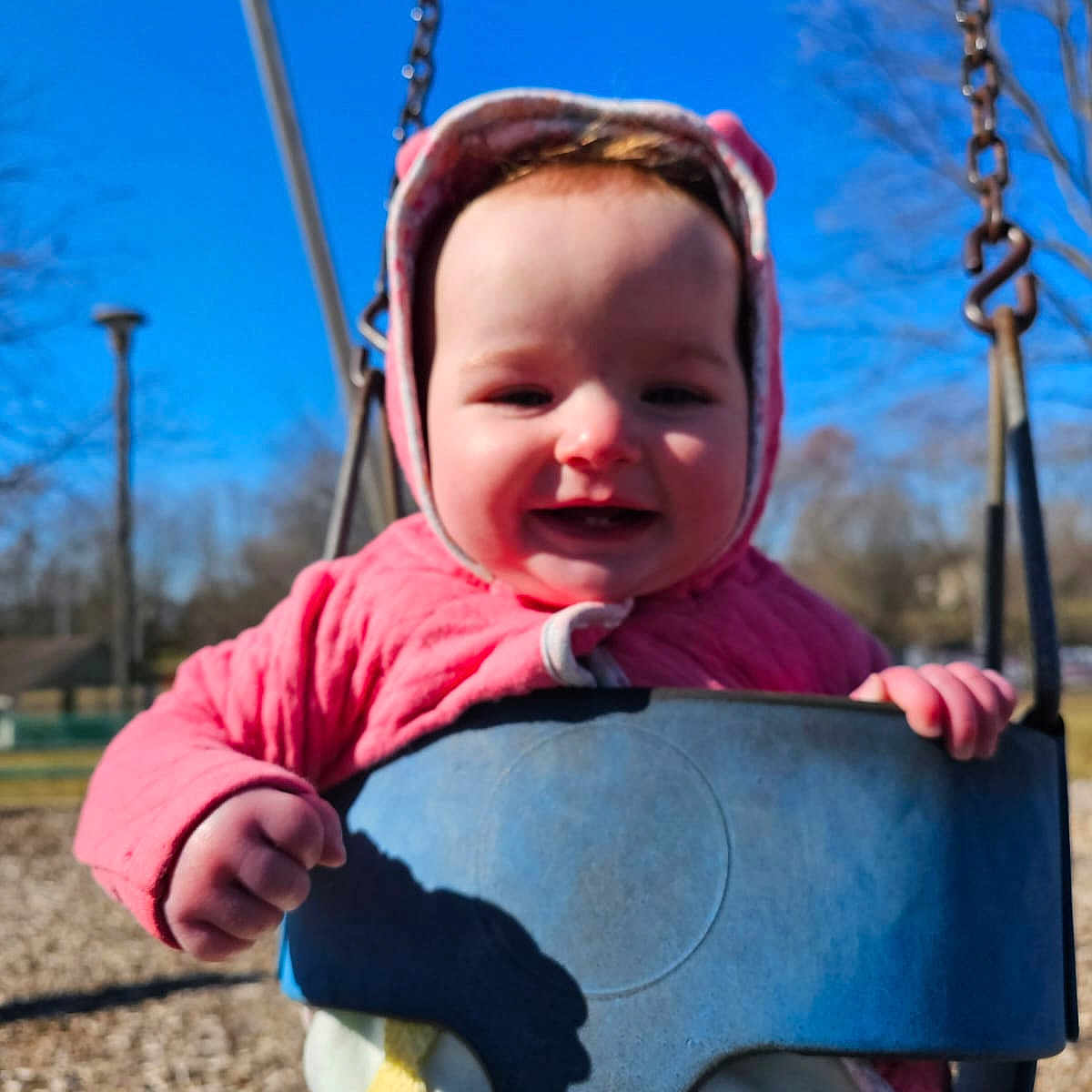 Noella is registered to the contest to win money with this photo: baby, clothing, coat, face, glove, grass, happy, head, jacket, nature, outdoorplayarea, outdoors, park, person, photography, plant, playarea, portrait, toy, tree
