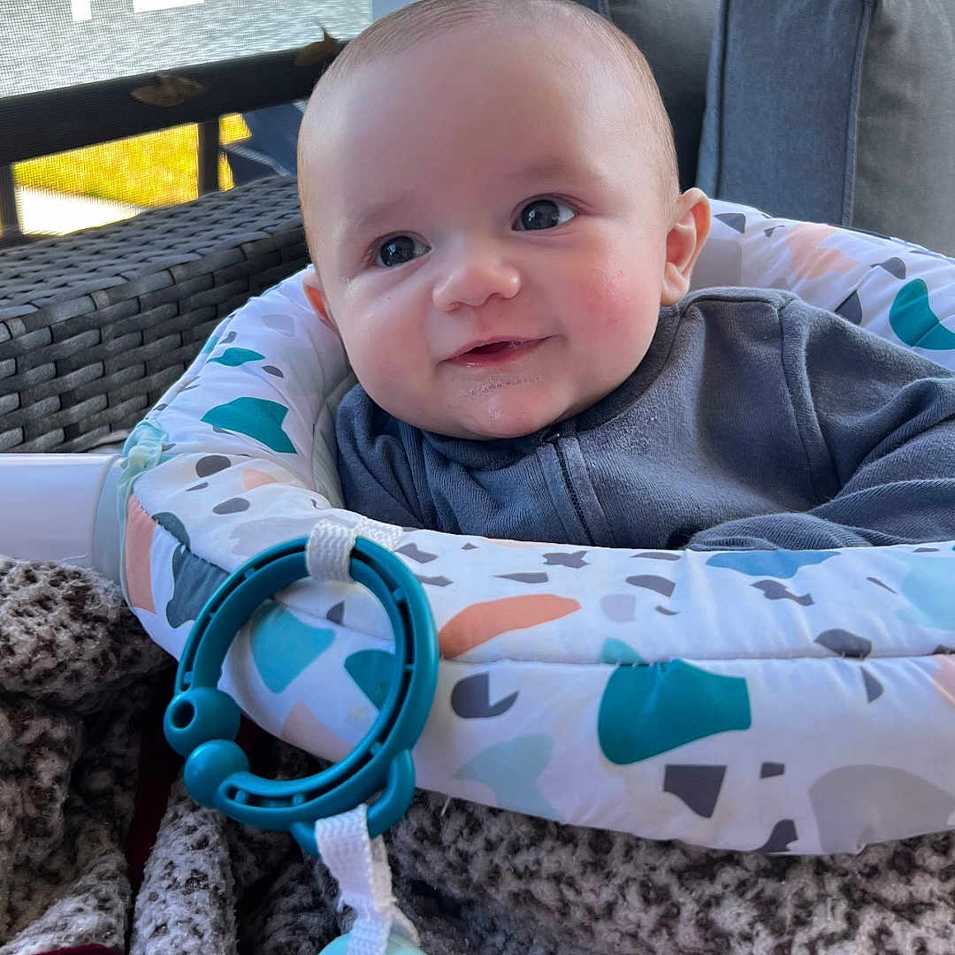 Michael is registered to the contest to win money with this photo: baby, blanket, clothing, coat, couch, cushion, face, furniture, happy, head, homedecor, jacket, machine, person, photography, portrait, quilt, smile, t_shirt, wheel