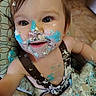 toddler, child, cake, frosting, messy, high_chair, smile, face, blue_frosting, white_frosting, food, happy, baby, clothing, hair, arm, table, celebration, dirt, fun