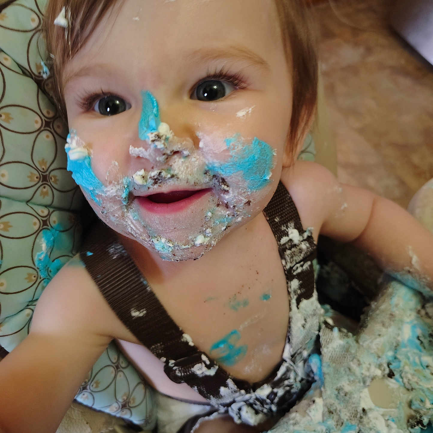 Ada joined the competition — help win amazing prizes! toddler, child, cake, frosting, messy, high_chair, smile, face, blue_frosting, white_frosting, food, happy, baby, clothing, hair, arm, table, celebration, dirt, fun