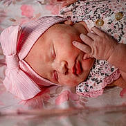 Delaney is registered to the contest to win money with this photo: baby, closeup, clothing, comfort, cute, face, floral_blanket, hand, hat, infant, newborn, nursery, peaceful, pink_bow, portrait, resting, skin, sleeping, soft, tiny
