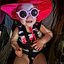 Charleigh is registered to the contest to win money with this photo: baby, child, sunglasses, hat, red_hat, stroller, seatbelt, smile, pointing, summer, sunhat, pink, clothing, infant, cute, happy, person, portrait, indoors, babywearing