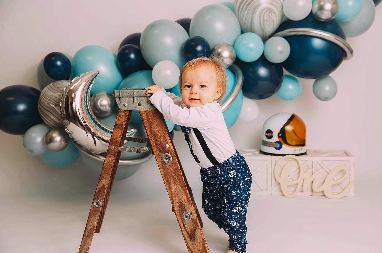 Benny is registered to the contest to win money with this photo: art, baby, balloon, chair, child, electric_blue, event, fun, happy, party_supply, person, picture_frame, product, room, sitting, stock_photography, t_shirt, textile, toddler, toy