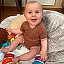 Clovis a rejoint le concours — aidez-le/la à gagner de superbes lots ! baby, blanket, bright, child, colorful, cozy, cute, expression, floor, furniture, happy, indoor, infant, onesie, person, playtime, sitting, smiling, toy, warm