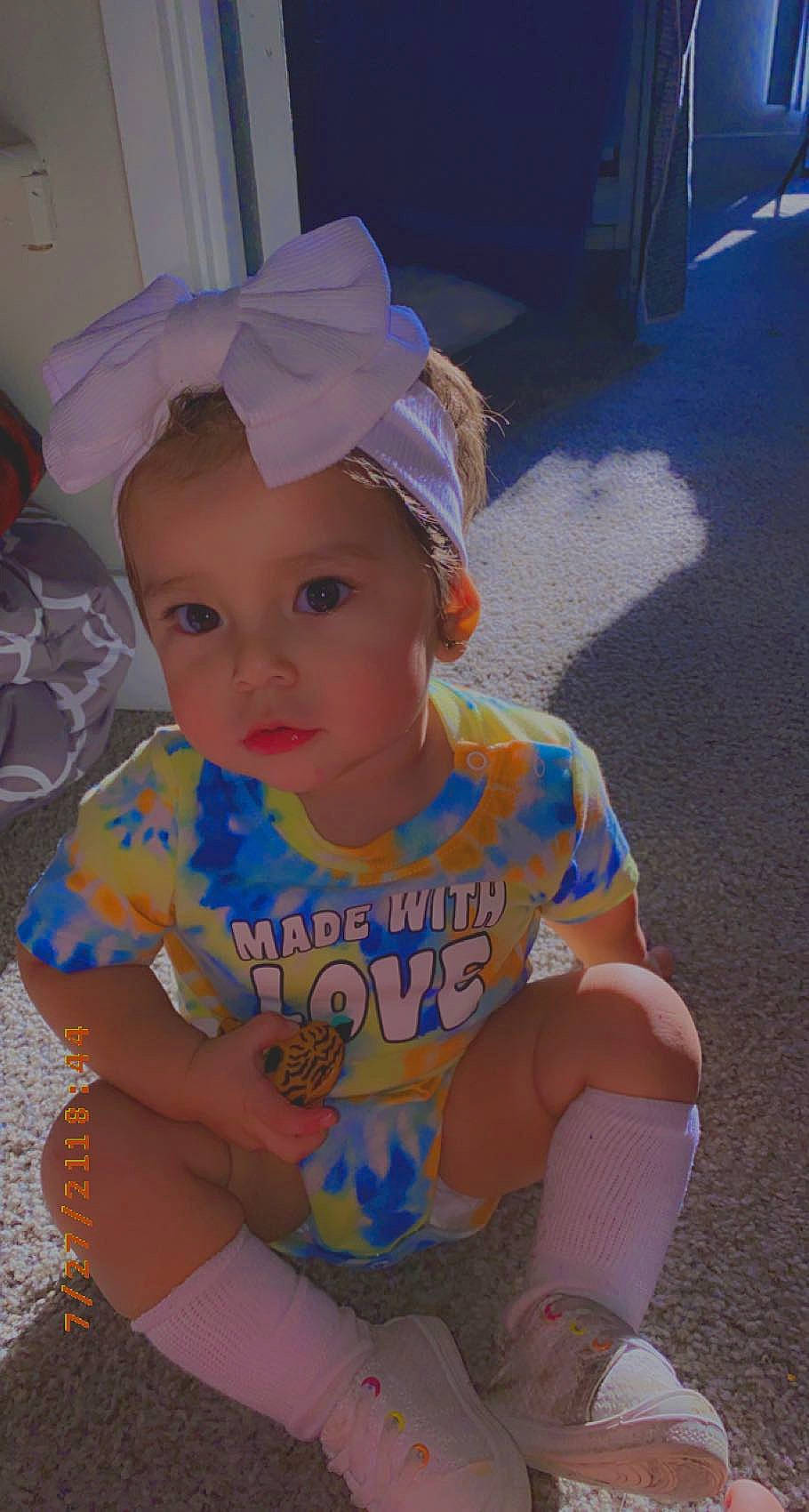 Love is registered to the contest to win money with this photo: baby, baby_toddler_clothing, cap, child, electric_blue, eye, fashion_accessory, fun, happy, hat, headgear, headwear, leisure, person, personal_protective_equipment, pink, play, sitting, skin, t_shirt