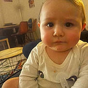 Anto Maria a rejoint le concours — aidez-le/la à gagner de superbes lots ! baby, chair, child, close_up, eyes, face, furniture, indoor, infant, living_room, neutral_expression, onesie, pacifier, pacifier_clip, portrait, rosy_cheeks, sitting, soft_lighting, table, warm_tone