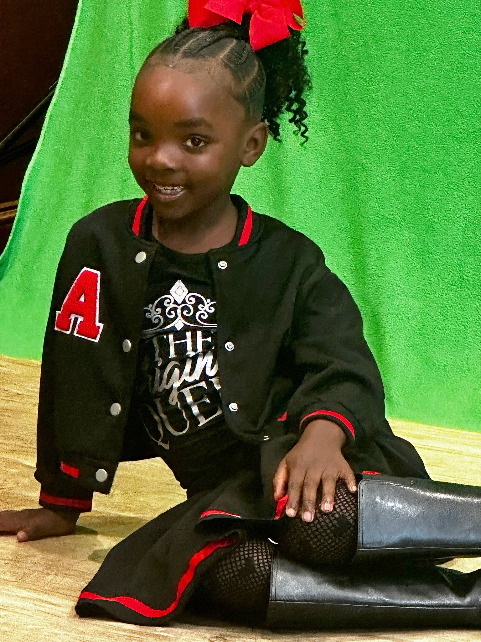 Allure is registered to the contest to win money with this photo: carmine, child, flooring, fun, happy, jersey, jewellery, joy, knee, pattern, person, player, red, sitting, sleeve, smile, sock, sportswear, t_shirt, thigh